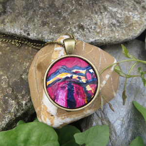 A vibrant handpainted pendant in magenta